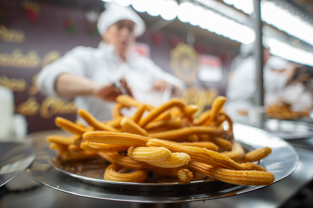 Bandeja de churros recién hechos en el puesto de Churrería Marga del mercado de Navidad de Valladolid